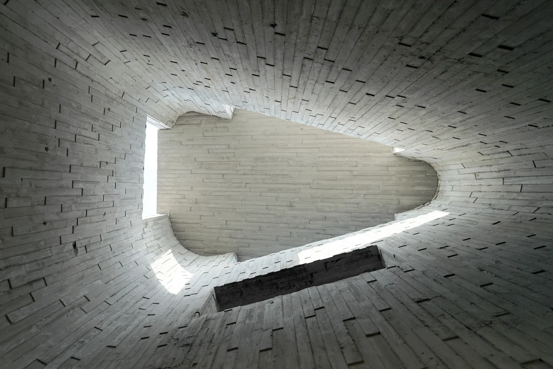 A sculptural concrete interior opening toward light
